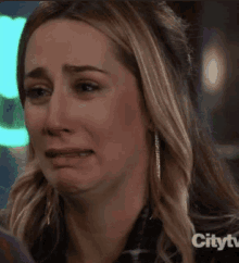 a close up of a woman 's face with tears coming out of her eyes .