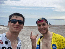 two men standing on a beach one wearing a nw network jersey