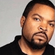 a man with a beard and mustache is wearing a black shirt .