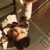 a man is hanging upside down with chains around his waist
