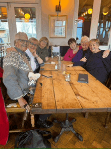 a group of people are sitting around a table with the number 8 on the table