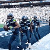 a group of football players are running on the field with a delta ad in the background