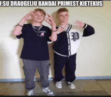 two boys are posing for a picture and one has the letter p on his shirt