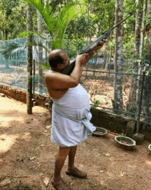 a man in a white towel is holding a rifle that says ' sniper ' on the barrel