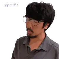 a man with a beard wearing glasses and a gray shirt