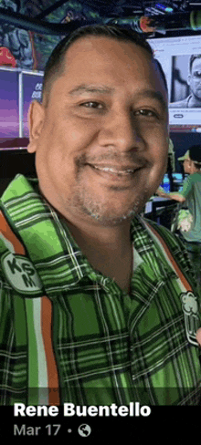 a man in a green plaid shirt is named rene buentello and is smiling