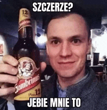 a man is holding a bottle of beer in his hand with a caption .