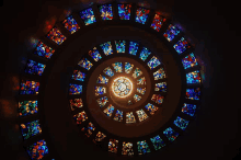 looking up at a spiral of stained glass windows in a church