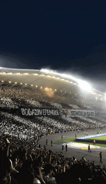 a crowd of people in a stadium with a banner that says bogazin efendisi on it