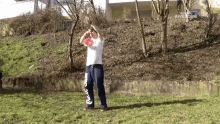 a man is throwing a frisbee in the air while wearing a white shirt with the word awesome on it .