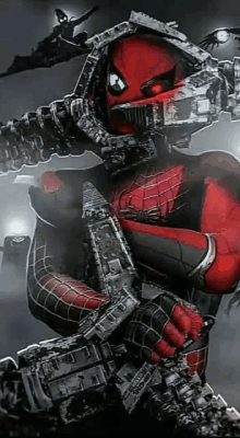 a close up of a spiderman holding a machine gun in his hands .