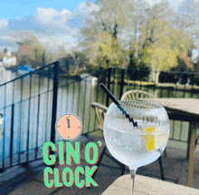 a glass of gin sits on a table next to a sign that says gin 's clock