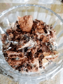 a glass bowl filled with a mixture of chocolate and oreos