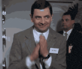 a man in a suit and tie with a name tag that says dr. bean