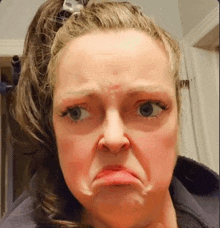 a woman with a ponytail is making a funny face with her mouth open .