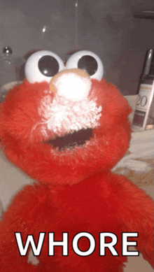 a stuffed elmo with the word whore on the bottom right