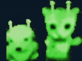 a couple of green stuffed animals are standing next to each other on a black background .
