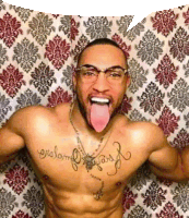 a shirtless man with glasses and a tattoo on his chest is sticking his tongue out in front of a curtain .