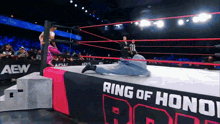 a wrestler is laying on the floor in a ring that says ring of honor