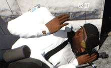 a man in a white suit is laying on the ground with the numbers 02-07 visible