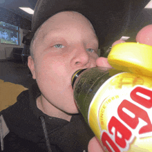 a young man drinking from a bottle that says ' since 1888 ' on it