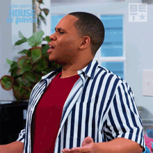 a man in a striped shirt is singing in front of a sign that says house of payne
