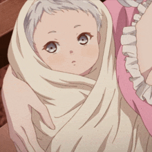 a baby wrapped in a white blanket is looking at the camera