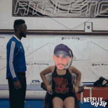 a netflix gif shows a man and a woman in front of an athletic banner