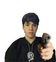 a young man is holding a gun in front of his face .