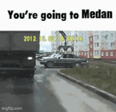 a truck with the year 2012 on the back is driving down a street