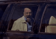 a man is sitting in a car with his mouth open and yelling .