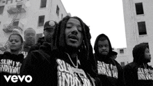 a black and white photo of a group of men wearing hoodies with the word vevo on it