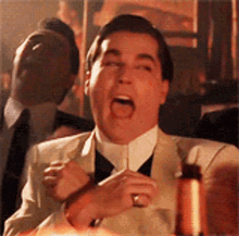 a man in a suit and tie is making a funny face .