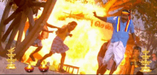 a group of people are dancing in front of a large fire .