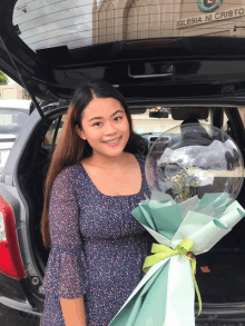 a woman is holding a bouquet of flowers in front of a building that says " iglesia ni cristo "