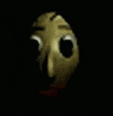 a close up of a cartoon character 's face in the dark with a red mouth .