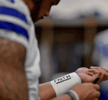 a football player wears a wristband that says faith on it