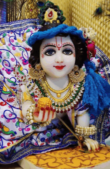 a statue of a baby krishna with a peacock feather on his head