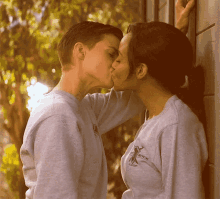 a couple kissing with one wearing a sweatshirt that says ' rock ' on it