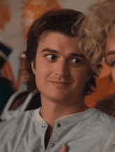 a close up of a person 's face with a woman behind him