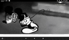 a black and white cartoon of mickey mouse is being played on a cell phone .