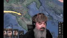 a man with a beard wearing headphones and a fur hat is playing a video game