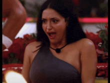 a woman in a one shoulder dress is making a funny face .