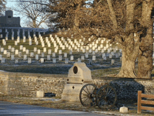 a cemetery with many graves and a wagon wheel in front