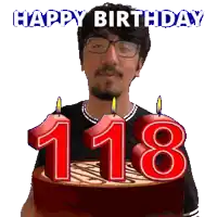 a man with glasses is holding a birthday cake with candles in the shape of the number 118