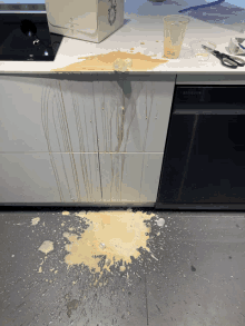 a samsung dishwasher sits next to a counter that has spilled liquid on it