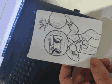 a person is holding a drawing of a ninja with a bomb in his hand