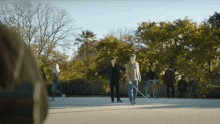 a group of people standing on a sidewalk with trees in the background and the word booth on the bottom left