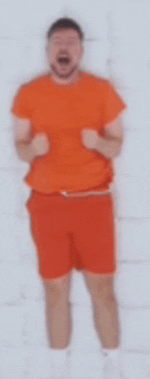 a blurry picture of a man in an orange shirt and shorts