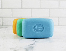 three bars of white rain soap sit on a counter top